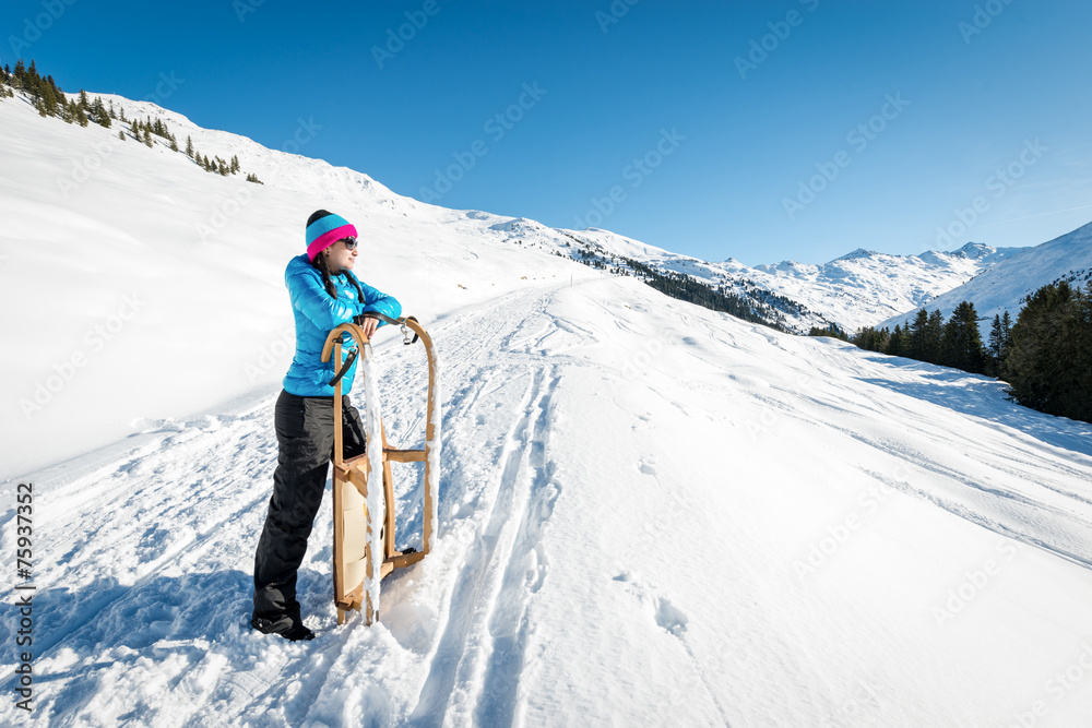 Young woman with a sledge enjoying winter