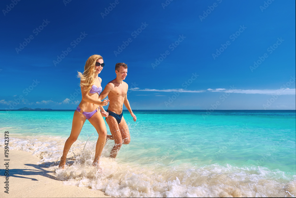 Happy couple running on the beach