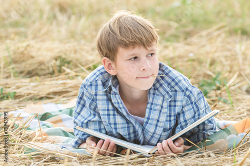 Teenage boy dreaming reading book photo