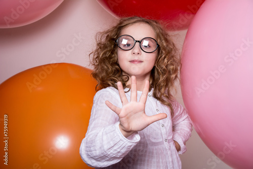 Portrait of a teenage schoolgirl showing five fingers on a backg