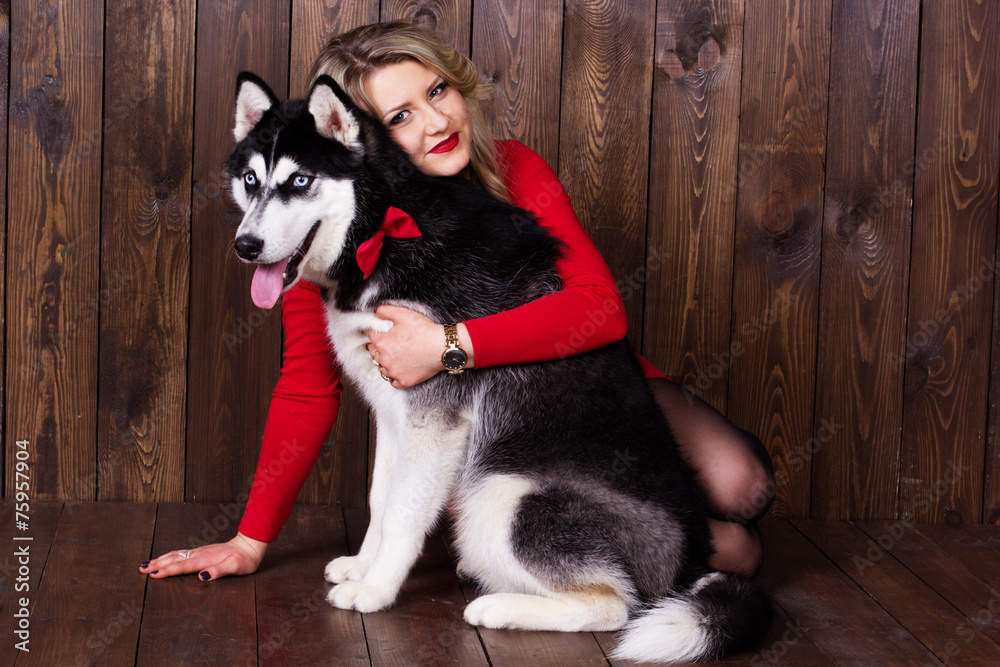 Young girl wearing red dress with her husky dog