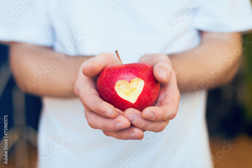Red apple with cutted heart photo