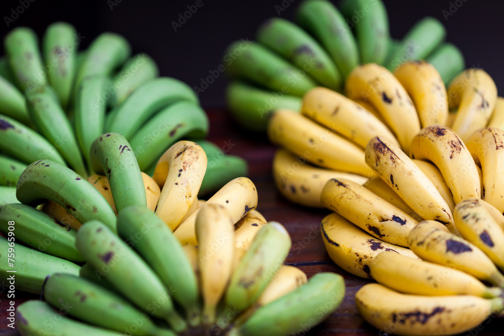 Banana in market. Bunches of ripe yellow and unripe green banan Banana in market. Bunches of ripe yellow and unripe green banan
