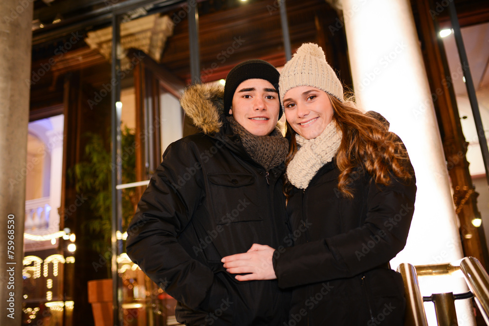 happy young couple having fun downtown at night during winter