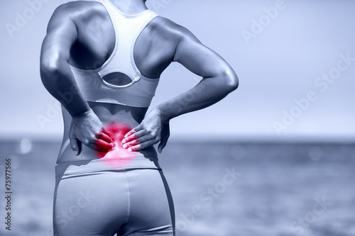 Back pain. Athletic running woman with back injury