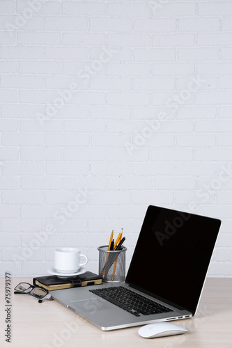 Modern laptop on table, on white wall background