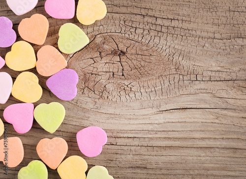 Colorful candy hearts on wooden background