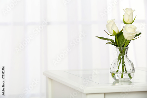 Beautiful bouquet of flowers in vase on window background