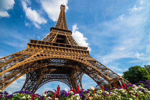 Wide shot of Eiffel Tower with dramatic sky and flowers