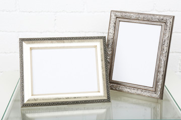 Photo frames on coffee table on brick wall background
