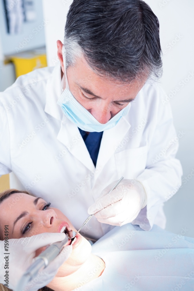 Dentist examining a patients with angled mirror Dentist examining a patients with angled mirror