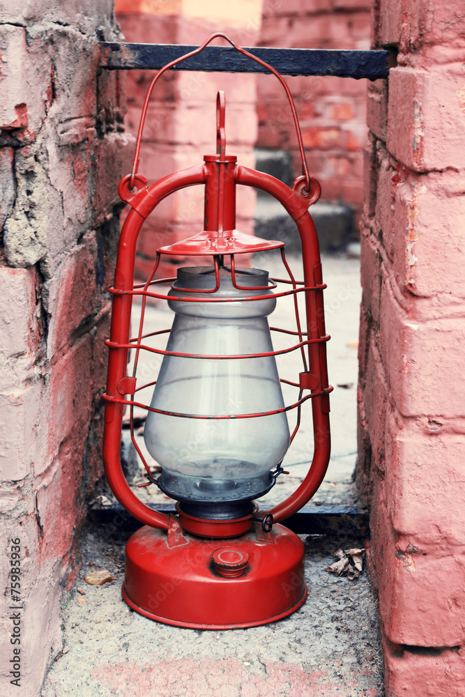 Kerosene lamp on ruined brick wall background