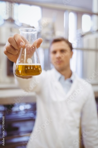 Thoughtful scientist holding a beaker