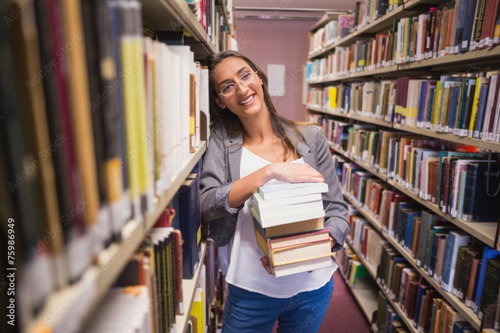 Pretty student smiling at camera in library Pretty student smiling at camera in library