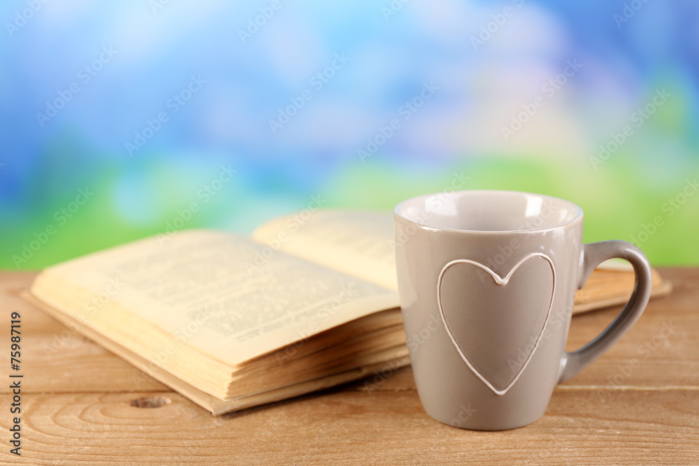 Cup of tea and book on table, on bright background Cup of tea and book on table, on bright background