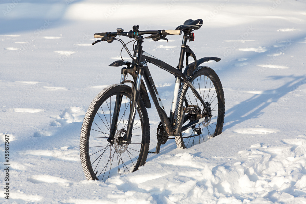 Bicycle on the street covered with snow Bicycle on the street covered with snow