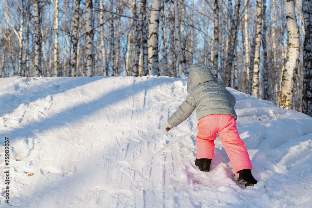 A little girl climbing up on a hill A little girl climbing up on a hill