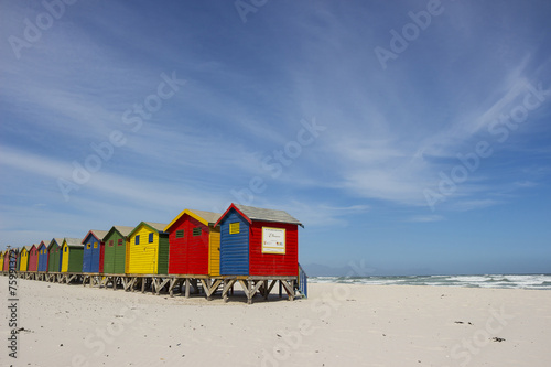 Colourful wooden buildings on Muizenberg beach with kelp