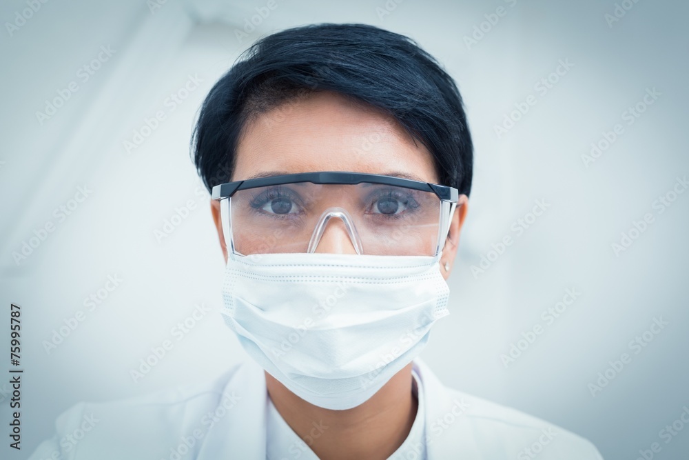 Dentist wearing surgical mask and safety glasses Dentist wearing surgical mask and safety glasses