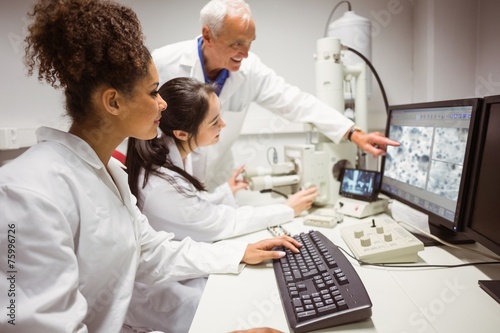 Science students looking at microscopic image on computer © WavebreakmediaMicro