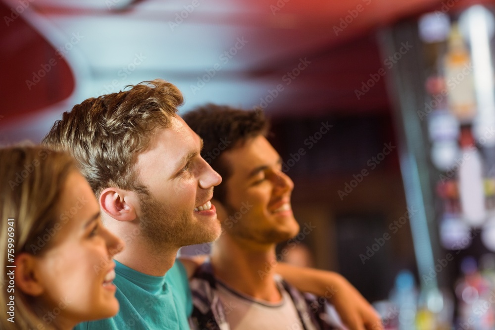 Smiling brown hair standing with arm around his friends Smiling brown hair standing with arm around his friends