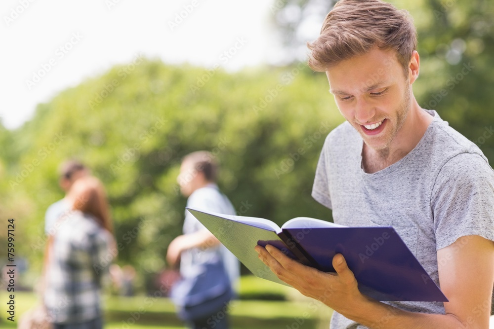 Fototapeta premium Handsome student studying outside on campus