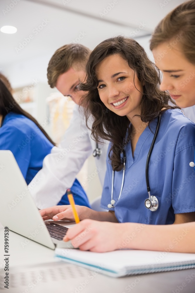 Medical student smiling at the camera during class Medical student smiling at the camera during class
