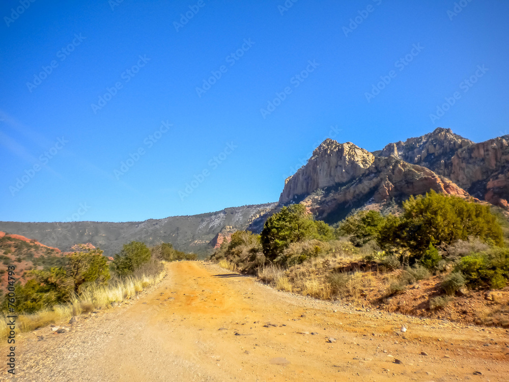 Fototapeta premium Unpaved dirt road drifting with mountains
