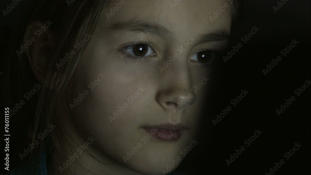 Closeup shot of little girl eye surfing internet at night
