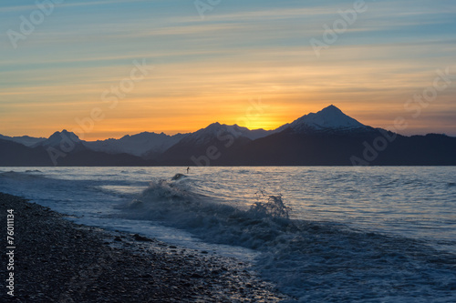 A surfer paddles out in waves on Kachemak Bay photo