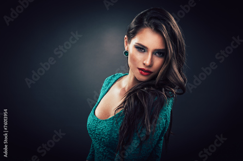 Beautiful young woman in a green dress with curly long hair