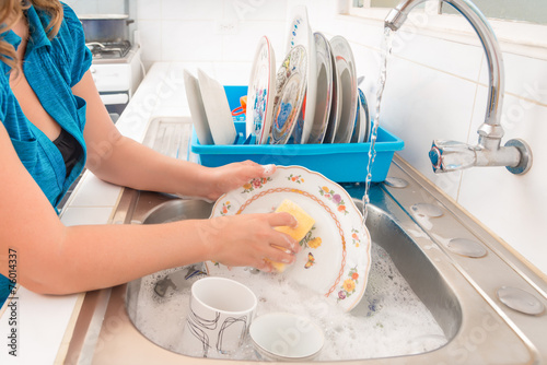 Washing the dishes in the kitchen sink photo