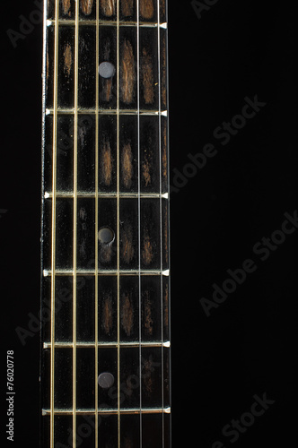 Acoustic guitar fretboard isolated on the dark background