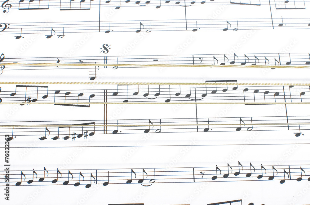 Six metal acoustic guitar strings over sheet music notes Six metal acoustic guitar strings over sheet music notes
