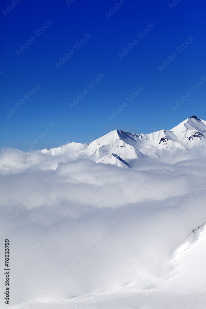 Mountains in clouds at nice winter day