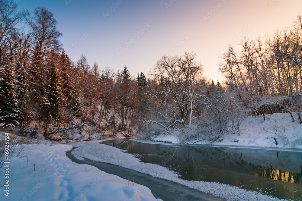 Winter frosty landscape at sunset in the forest with a river Winter frosty landscape at sunset in the forest with a river