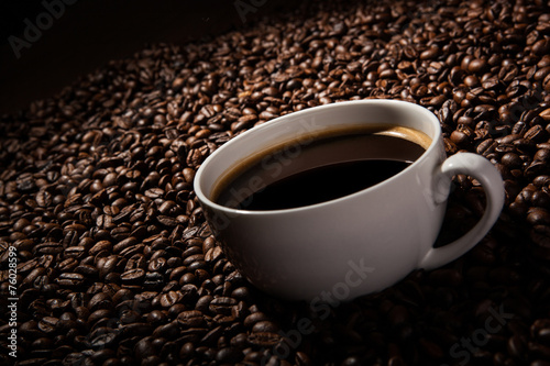 Still-life with a cup of black coffee and roasted coffee beans