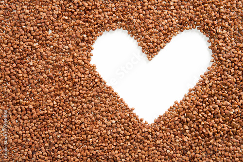 Heart shape made of premium buckwheat groats on white background