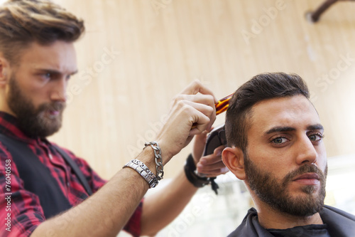 young hipster barber cuts her hair before the pomade