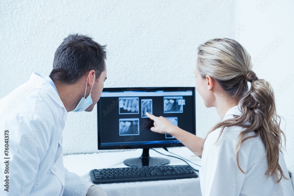 Dentists looking at x-ray on computer Dentists looking at x-ray on computer
