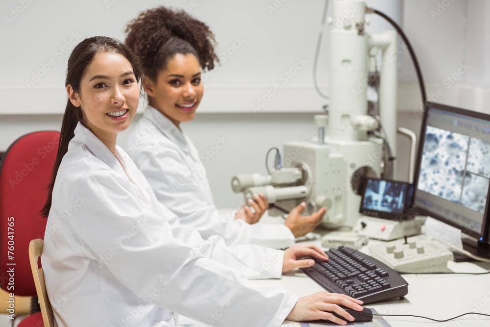 Science students working with microscopic image on computer Science students working with microscopic image on computer