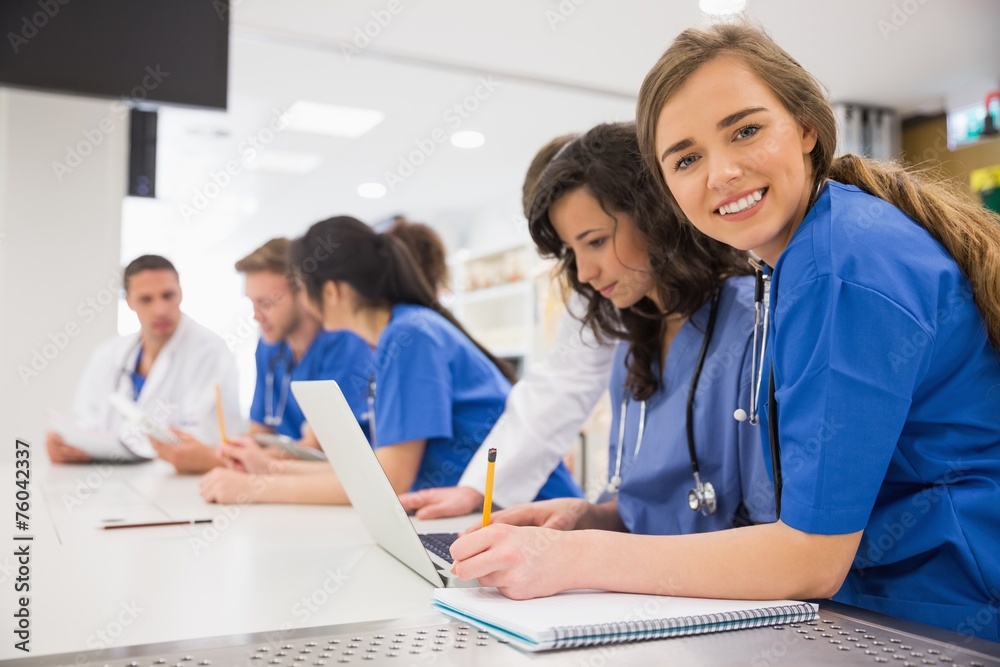 Medical student smiling at the camera during class Medical student smiling at the camera during class