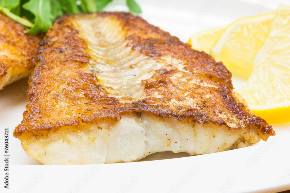 White fish with lemon on white plate