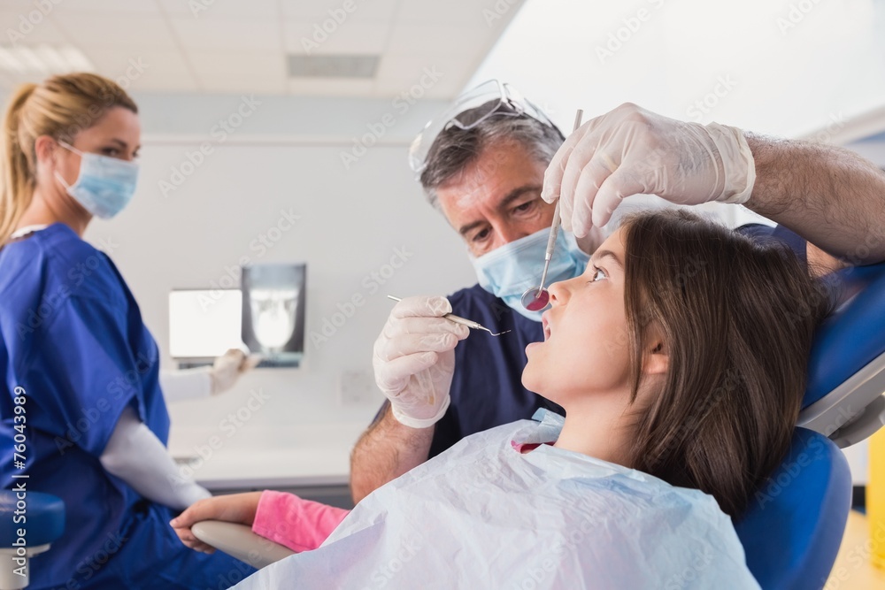 Pediatric dentist examining her young patient Pediatric dentist examining her young patient