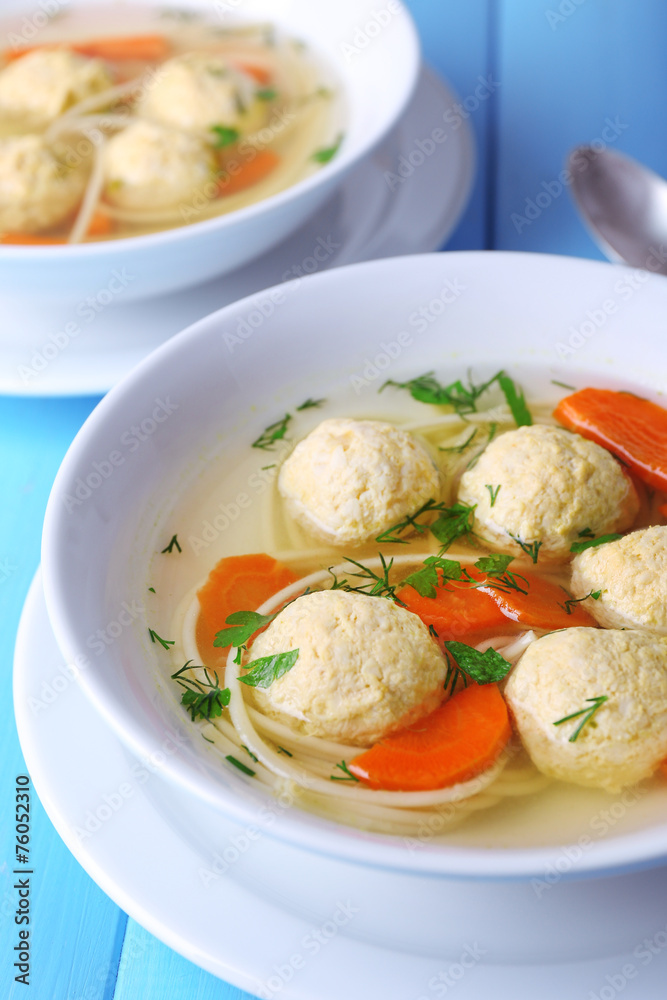 Soup with meatballs and noodles in bowls