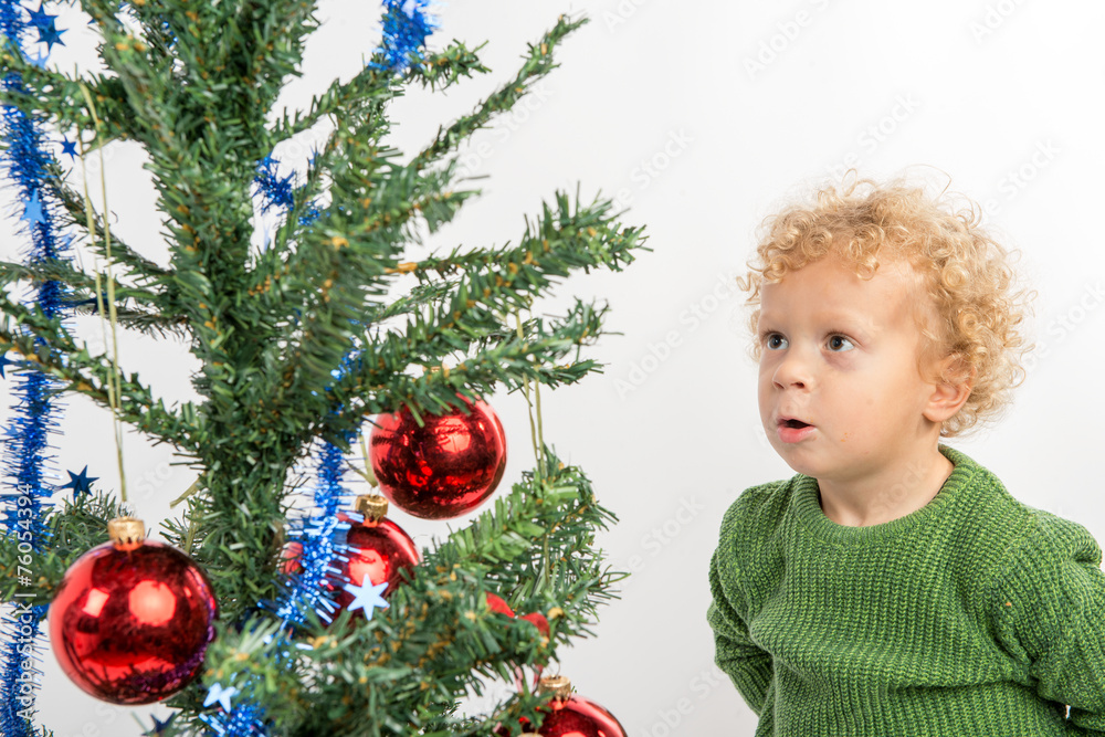little boy looking at the Christmas tree with envy little boy looking at the Christmas tree with envy