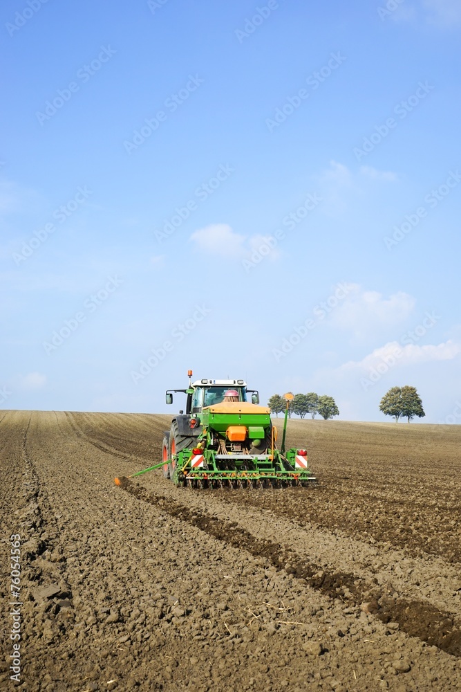 Fototapeta premium Acker´bau: Schlepper mit Drillmaschine bei der Herbstbestellung