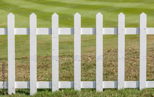 Close up the white wooden fence with green meadow background. © mrcmos