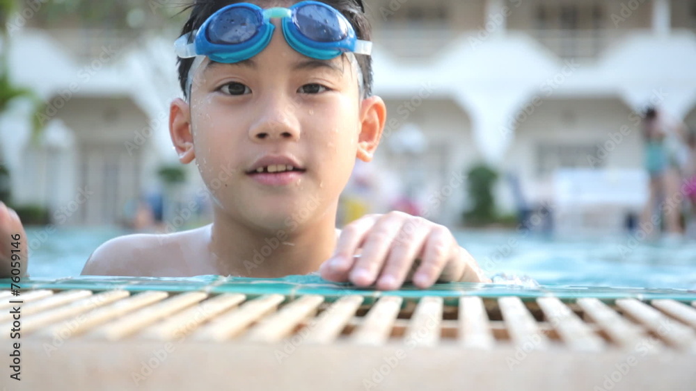 Little Asian cute child playing in the swimming pool .