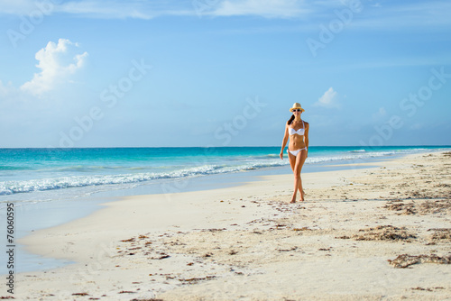 Sexy tanned woman in bikini on tropical natural beach